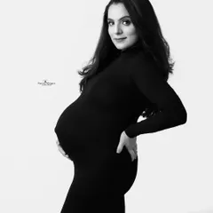 A classic black and white maternity portrait. The simple side profile pose is elegant and timeless, beautifully showcasing the baby bump.
