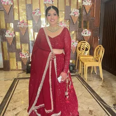 A full view of this classic red lehenga look. The simple, elegant bun and minimal makeup create a timeless and sophisticated style.