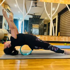 A student using a yoga wheel during a private session at home. We bring props and expertise to your doorstep to help you deepen your practice and work on specific goals, like this advanced backbend.
