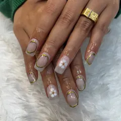 A close-up of the gold chrome frame and 3D flower nail art. This design is done on soft gel extensions, which provide the perfect canvas for such detailed work.