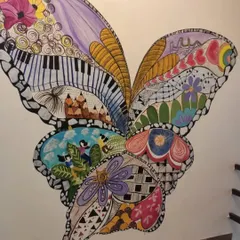 A custom wall mural I painted, featuring a large butterfly with wings filled with intricate doodles, patterns, and meaningful images like a piano and pencils. This was a very personal and creative project.