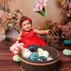 From the same floral session, this shot captures a moment of curiosity as she holds a lily. Sitter sessions are full of movement and discovery, and I make sure to capture these candid, interactive moments as well as the posed smiles.