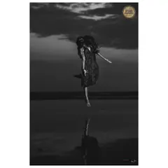 This image, which received an Honourable Mention at the Black & White Spider Awards, is called 'The Blessing'. It explores a sense of freedom and connection to the elements, capturing a moment of pure, weightless expression against the evening sky.