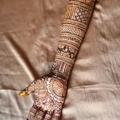I love adding personal touches, like hiding the groom's initials within the bride's mehndi. Here, the letters 'AR' are woven into the detailed design on the palm, a sweet and secret tribute.