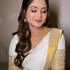 Soft South Indian bridal elegance. This look features soft, closed eyes to showcase the warm, neutral eyeshadow that complements her traditional white and gold saree.