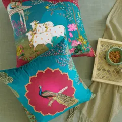 A closer look at our Pichwai art cushions, featuring the iconic cow and peacock motifs. The rich teal and magenta fabrics are printed with these traditional designs, telling stories of Indian folklore and artistry.