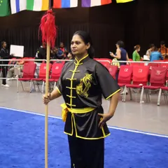 Standing ready with a staff (gun) at an international competition. The staff is one of the first weapons a student learns, known as 'the father of all weapons' in Kung Fu.