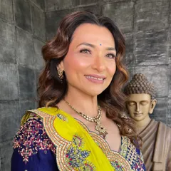 A close-up portrait of the mother of the bride. The makeup is subtle, with a focus on evening out the skin tone and adding a warm, healthy glow.