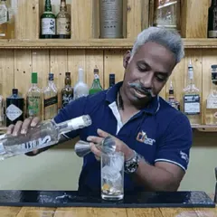 Pouring a measure of vodka for a classic cocktail. My setup includes all the necessary professional bartending tools and a wide range of spirits to craft any drink your guests desire.