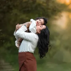 This playful lift between a mother and her baby is just pure joy. I love capturing these energetic, happy moments during our outdoor family photoshoots.