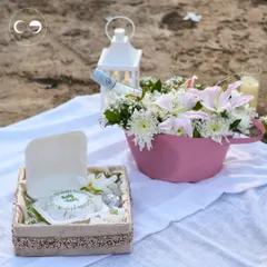 A romantic picnic proposal we set up on the beach. The setup included a cozy blanket, a lantern, a gourmet cake, and a bucket of fresh flowers, creating an intimate and picturesque moment.