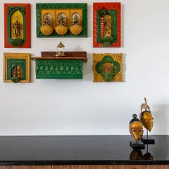 This charming puja area is combined with a crockery unit. The wall is adorned with colorful, framed decor of Hindu deities, creating a vibrant and spiritual corner in the home.