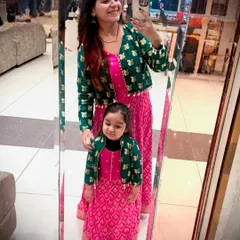 A mirror selfie showing off our matching mom-daughter outfits. This view highlights how the fabric from a single saree was used to create two complete, coordinated looks.