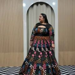 A beautiful plus-size client in a stunning black lehenga with colorful floral embroidery. The keyhole neckline and full sleeves make it a stylish and comfortable choice for any celebration.