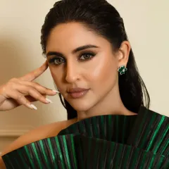 This angle highlights the smooth, airbrushed quality of the skin finish and the clean lines of the eye makeup. The wet-look hair is pulled back to keep the focus entirely on her face and the statement dress.