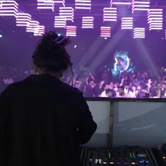 A view from behind the decks, looking out at a huge festival crowd. This is my office, and I have the best view.