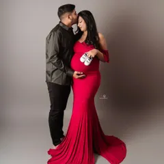 A classic pose that says it all. The vibrant red gown makes a beautiful statement, and the tiny shoes are a sweet hint of the little one on the way.