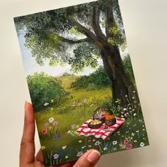 This piece captures the simple joy of a picnic in a wildflower meadow. I used gouache on paper to paint the checkered blanket, the basket of treats, and the peaceful landscape under a big tree.