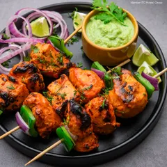 We present our classic Chicken Tikka, grilled to perfection. Each succulent piece is marinated in a blend of traditional spices, offering an authentic taste of India with a touch of modern culinary flair.