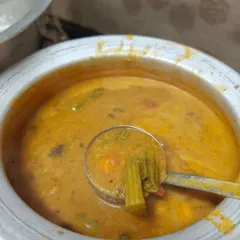A large pot of authentic South Indian sambar, full of vegetables like drumsticks and carrots. This was part of a breakfast catering order for an event, served alongside fresh idlis and pongal.