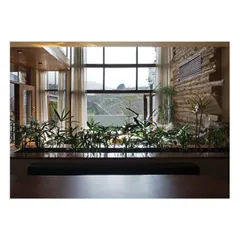 The dining area is designed to feel like a part of the landscape. A row of indoor plants acts as a natural screen, separating the space while still allowing views of the hills through the large windows, making every meal feel connected to nature.