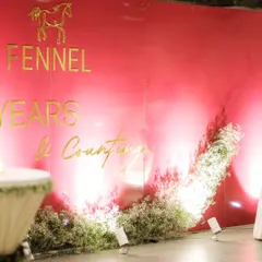 The simple yet elegant backdrop for Fennel's 15th anniversary, with soft lighting creating a beautiful gradient effect on the pink wall.