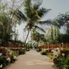 An outdoor engagement ceremony path I designed, lined with lush greenery and white floral arrangements. The aisle leads to a simple, elegant arch, creating a beautiful, natural setting for the couple to exchange rings.