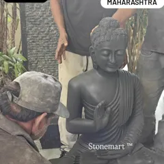 An artisan inspects the final details of a 3-foot black marble Abhaya Mudra Buddha statue before it is prepared for shipping to Nashik.