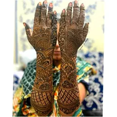 A classic bridal henna pose showing the detailed artwork on both the front and back of the hands. I focus on creating symmetrical yet unique patterns for each hand that complement each other perfectly.