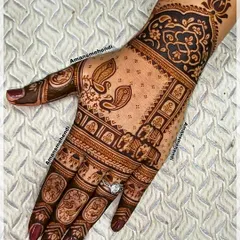 A beautiful back-hand design filled with traditional elements. It includes rows of elephants, pairs of peacocks, and floral patterns on the fingers.