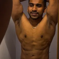 A mirror check showing abdominal and chest definition. Staying lean requires a consistent and clean diet, which is a critical component of my contest prep programs.