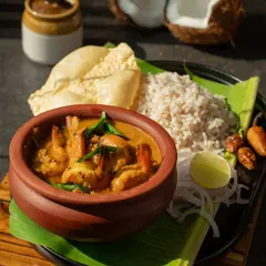 A stunning shot of Kerala-style prawn curry for Potpourri World. The use of a traditional clay pot and banana leaf adds authenticity and visual appeal.