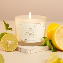 A bright and airy shot of a lemon and mint scented candle, styled with fresh lemons. Using ingredient props is a great way to visually communicate a candle's fragrance.