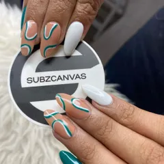 A stylish and artistic set featuring abstract teal and white lines over a nude base. The combination of negative space and solid color nails creates a balanced and eye-catching design.