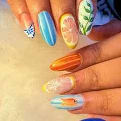 This playful, summery set features different hand-painted designs on each nail. We included citrus slices, stripes, leaves, and even a tiny goldfish for a fun and unique manicure.