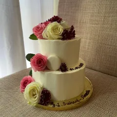 An elegant two-tiered engagement cake. This 2kg chocolate sponge cake with dark chocolate ganache is decorated with a beautiful arrangement of fresh pink and white roses.