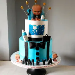 A stylish Boss Baby cake for a first birthday. This two-tiered design features a "suit and tie" bottom tier and a topper of the Boss Baby himself, complete with his briefcase and bottle.