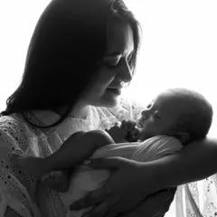 A close-up of a mother gazing at her newborn baby. The black and white edit adds a timeless, classic feel to this intimate moment.