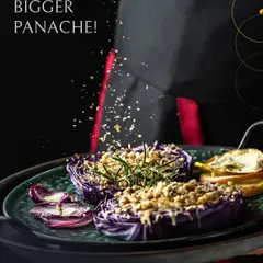 Big plates, bigger panache. This dish features roasted purple cabbage halves, generously topped with a crunchy crumble and fresh rosemary, served by one of our chefs. It's a testament to how we can transform simple ingredients into a gourmet experience.