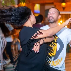 A candid moment of social dancing. This is what it's all about: moving to the rhythm, connecting with your partner, and letting your hair fly.