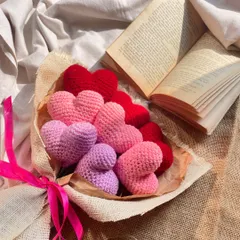 A beautiful shot of the heart bouquet, styled with an open book. The different shades of pink and red create a lovely ombre effect, making it a truly romantic gift.