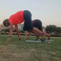 Perfecting the 'set' position in starting blocks on a grass field. This fundamental skill is crucial for getting an explosive start in any sprint event.