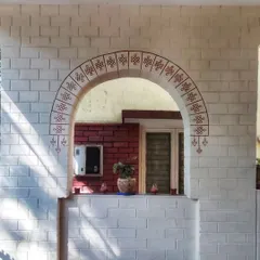 We painted a minimal Kolam border around this archway to add a subtle traditional touch to the home's entrance. It shows how we can work with existing architectural features like brick walls.