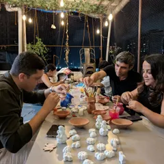 The studio truly comes alive at night. Under the glow of string lights, friends and groups gather to paint their creations, turning simple clay into personal treasures.