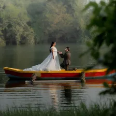 A wide shot of the couple in a boat, surrounded by the morning mist on the lake. This image captures a sense of peace and endless love.