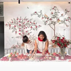 A beautiful Chinoiserie-style wallpaper featuring pomegranate trees and birds, creating an elegant and festive atmosphere in this dining space.