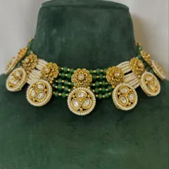 A beautiful choker with floral motifs and Kundan work, set on a base of green and white pearl beads. This piece is available for rent in Mumbai.