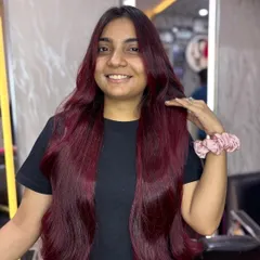 The happy client showing off her new cherry red hair. Her smile is as bright as her new color.
