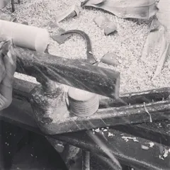 A black and white view of the traditional lathe, the heart of our workshop. This simple machine, combined with the skill of an artisan, is where every toy begins its life, surrounded by the fragrant shavings of Ivory wood.