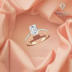 An elegant statement of love. This emerald-cut diamond is set on a delicate band paved with smaller diamonds, combining classic geometry with breathtaking sparkle.
